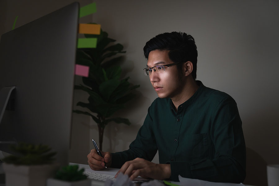 Man in STEM career doing programming on a desktop computer