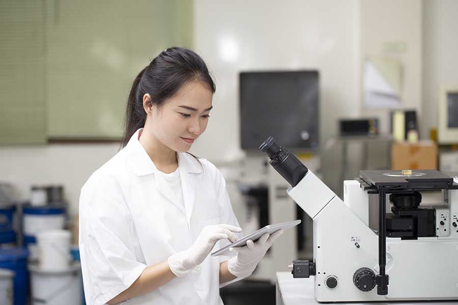 chemistry student using tablet to check on experiment results