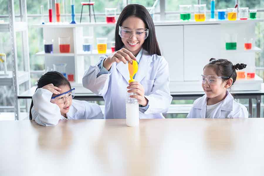 teacher and students perform chemistry experiment using ballon