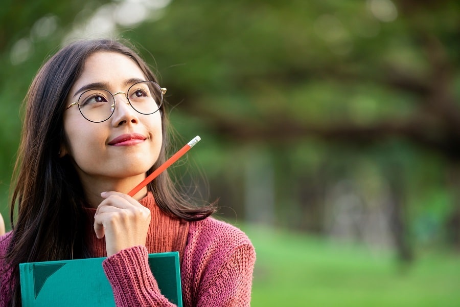 girl holding a pencil and thinking about her aspirations girl holding a pencil and thinking about her aspirations