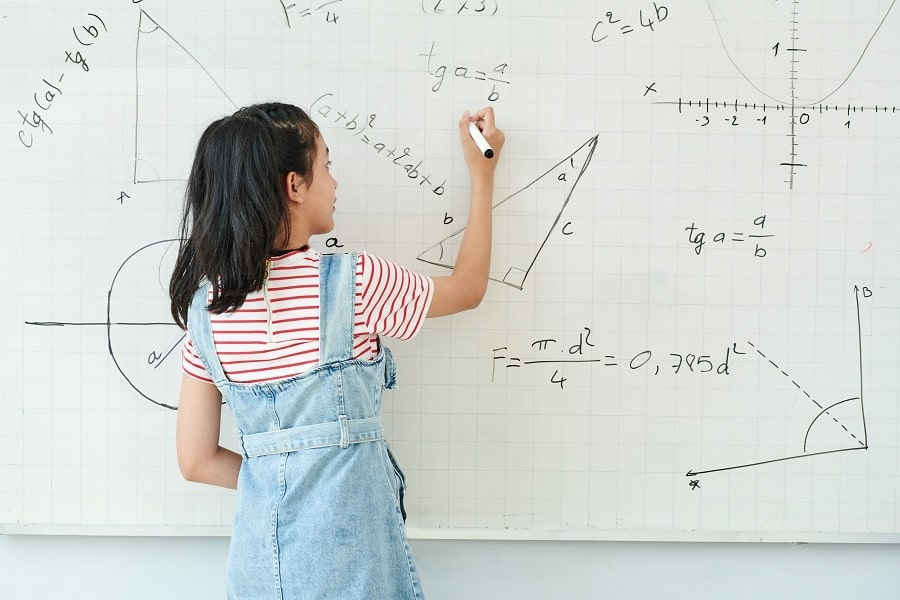 school girl writing math equations on the whiteboard school girl writing math equations on the whiteboard